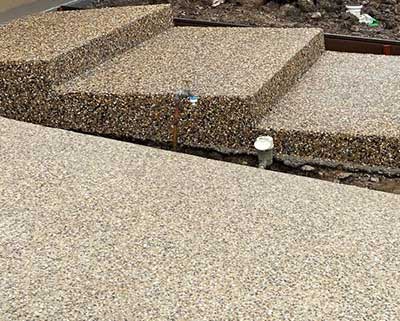 Exposed concrete wall being sandblasted for a refreshed look.